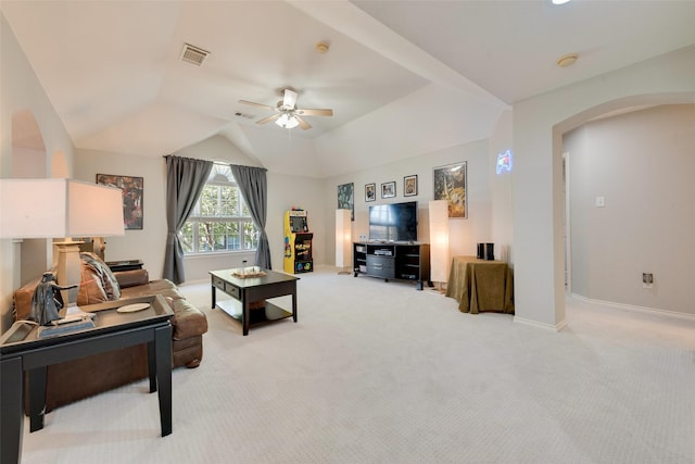 living room featuring arched walkways, lofted ceiling, visible vents, and light colored carpet