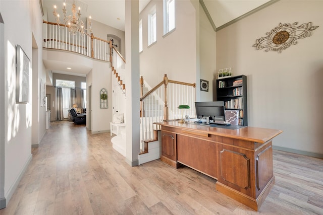 office space featuring light wood-style floors, baseboards, and crown molding