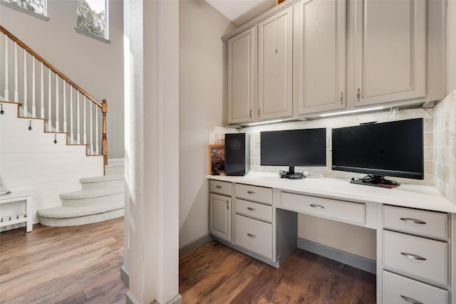 home office featuring built in study area and dark wood finished floors