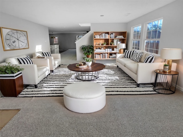 living room featuring carpet and stairway