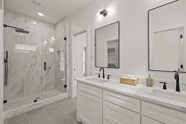 bathroom with double vanity, visible vents, and a sink