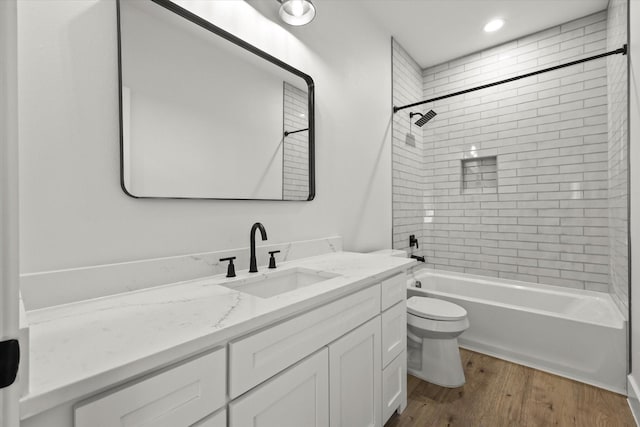 bathroom with toilet, wood finished floors, bathtub / shower combination, vanity, and recessed lighting