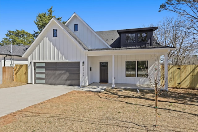 modern farmhouse style home with a porch, concrete driveway, an attached garage, board and batten siding, and fence