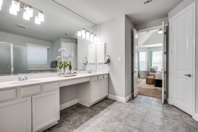 ensuite bathroom featuring double vanity, visible vents, and a sink