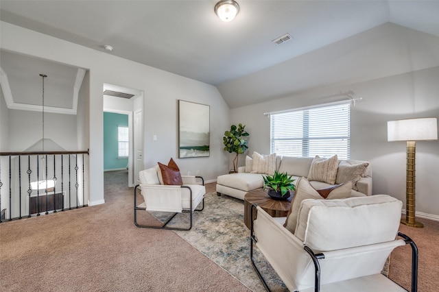 carpeted living area featuring a wealth of natural light, visible vents, vaulted ceiling, and baseboards