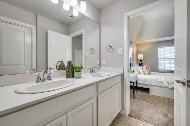 bathroom with double vanity, tile patterned flooring, a sink, and ensuite bathroom