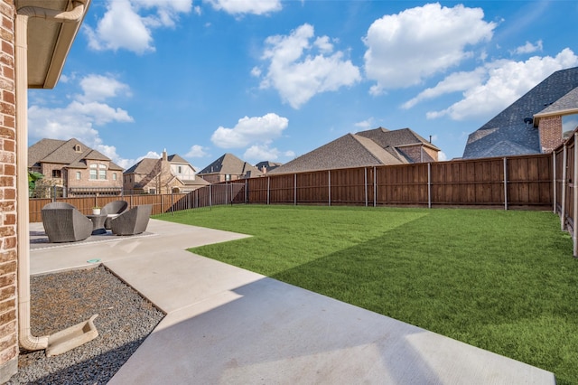 view of yard featuring a patio, a fenced backyard, and a residential view