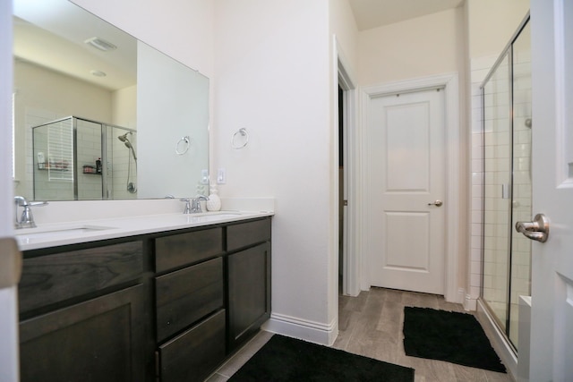 full bathroom featuring a stall shower, a sink, and visible vents