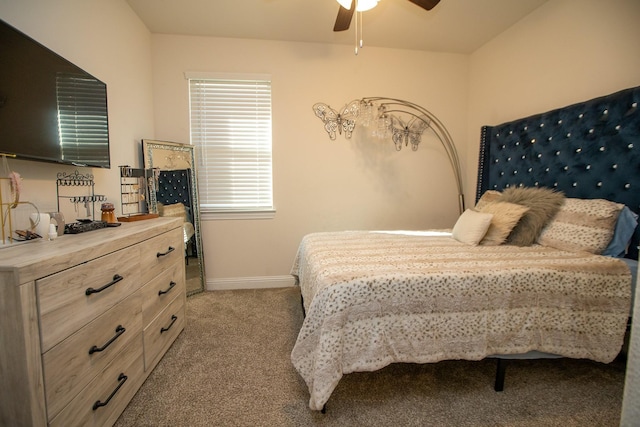 carpeted bedroom with ceiling fan and baseboards