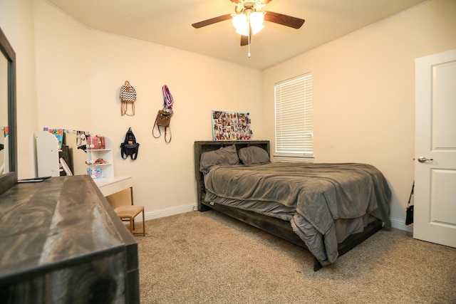 carpeted bedroom with ceiling fan and baseboards