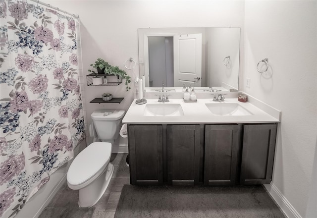 bathroom with double vanity, a sink, toilet, and a shower with curtain