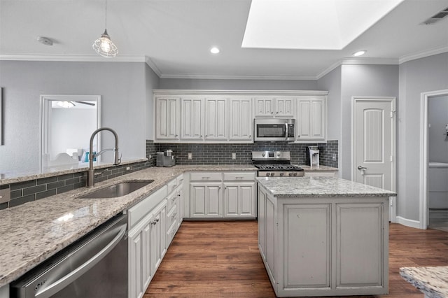 kitchen featuring dark wood-style floors, stainless steel appliances, visible vents, decorative backsplash, and a sink