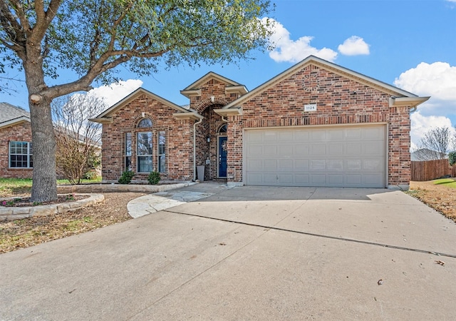 single story home featuring concrete driveway, brick siding, an attached garage, and fence