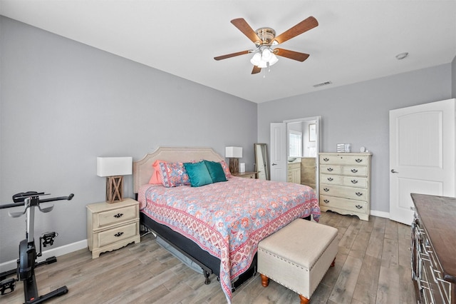 bedroom with a ceiling fan, light wood-type flooring, visible vents, and baseboards