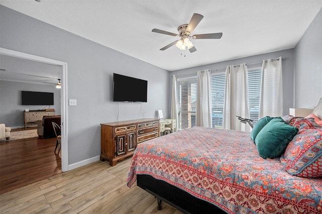 bedroom featuring light wood finished floors, ceiling fan, and baseboards