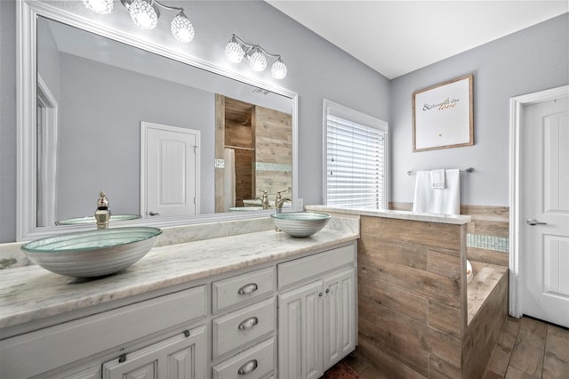 bathroom with double vanity, a stall shower, a sink, and a bath