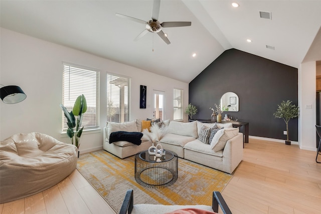 living room with lofted ceiling, light wood-style flooring, visible vents, and baseboards