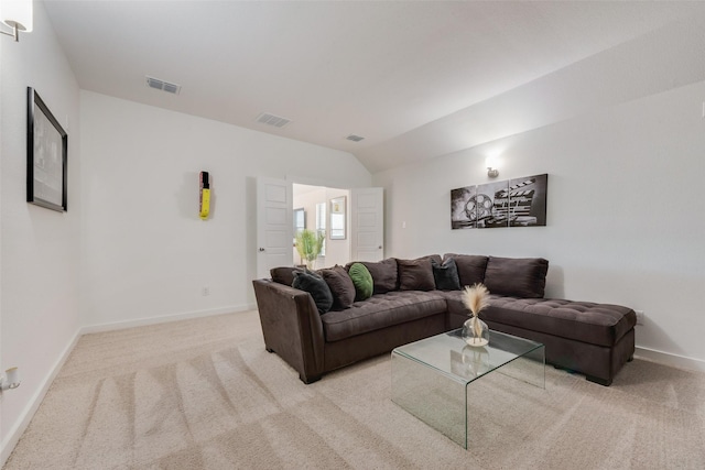 living room featuring lofted ceiling, visible vents, and light carpet