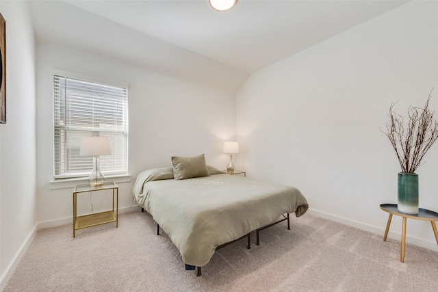 carpeted bedroom featuring vaulted ceiling and baseboards