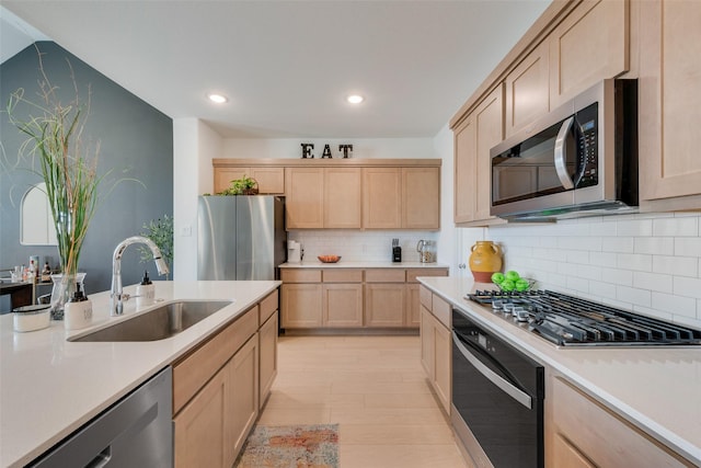 kitchen with stainless steel appliances, light countertops, light brown cabinets, and a sink