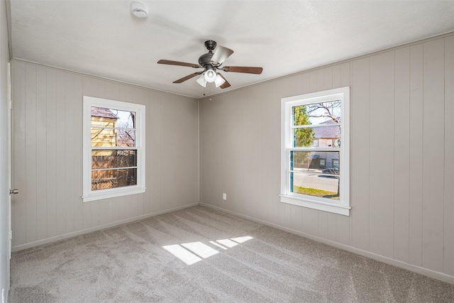 unfurnished room featuring carpet floors, ceiling fan, and baseboards