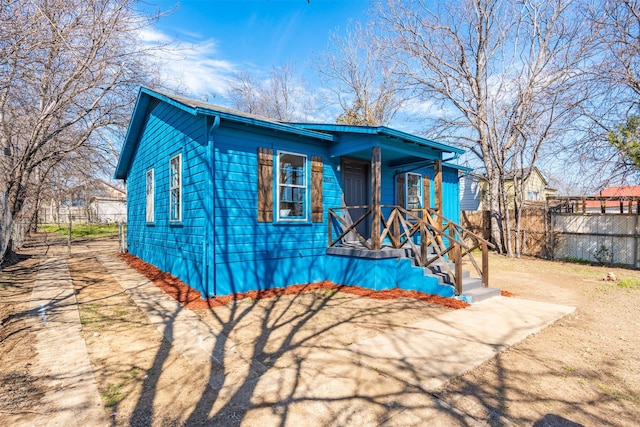 bungalow-style house with covered porch and fence