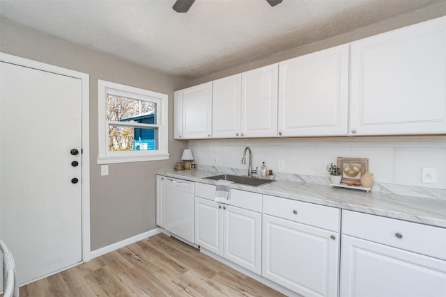 kitchen with a sink, white cabinetry, light countertops, dishwasher, and light wood finished floors