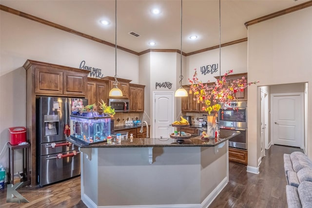 kitchen featuring stainless steel appliances, visible vents, ornamental molding, brown cabinets, and dark wood-style floors