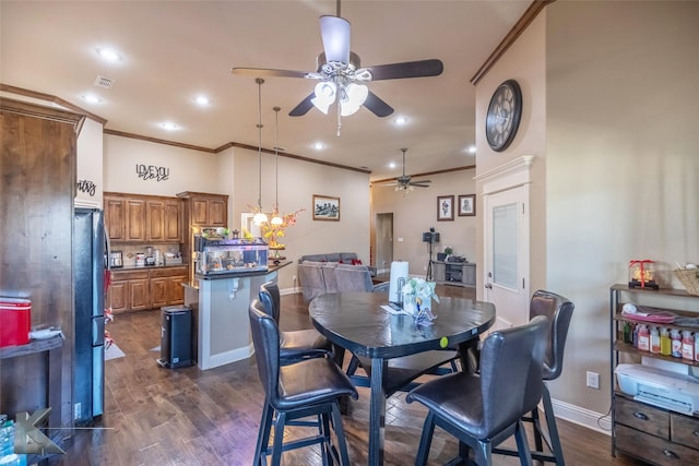 dining area featuring dark wood-style floors, ornamental molding, visible vents, and baseboards