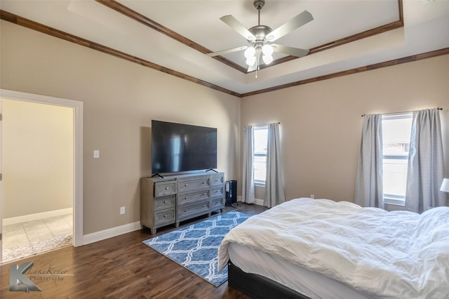 bedroom featuring ornamental molding, a tray ceiling, and dark wood-style floors