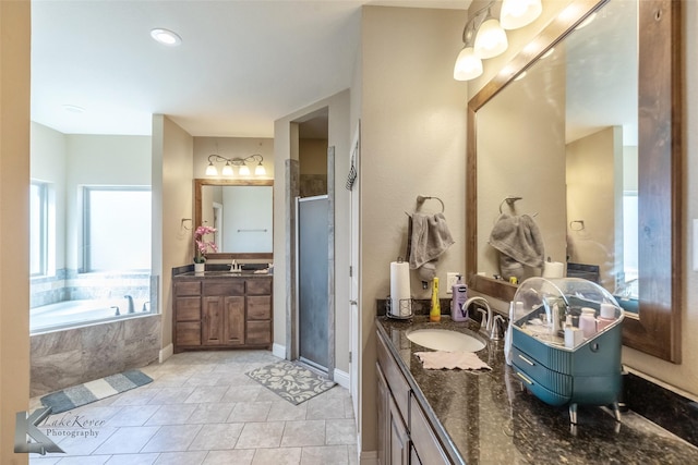 full bath with a stall shower, two vanities, a sink, and a bath