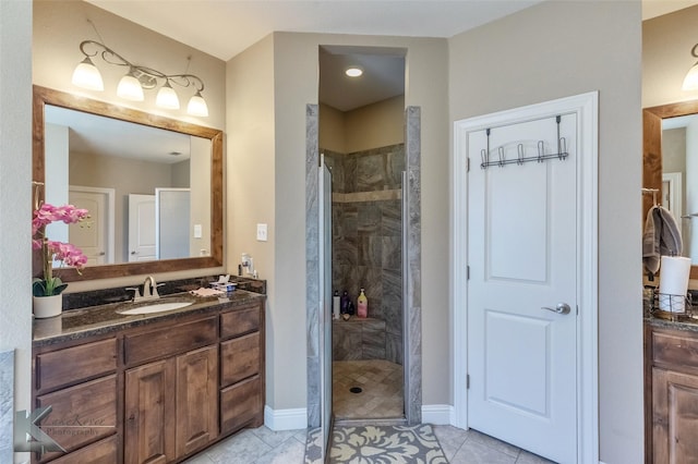 full bathroom featuring a shower stall, baseboards, tile patterned flooring, and vanity