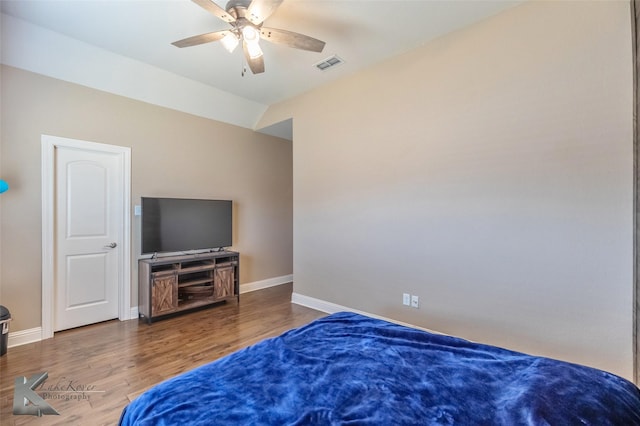 bedroom with lofted ceiling, baseboards, visible vents, and wood finished floors