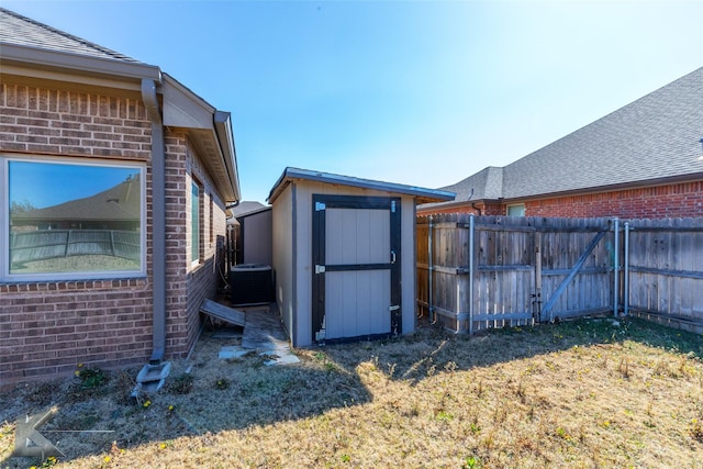 exterior space with central air condition unit, a shed, a fenced backyard, and an outdoor structure