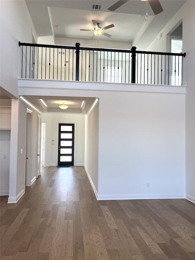 entrance foyer featuring visible vents, a high ceiling, baseboards, and wood finished floors