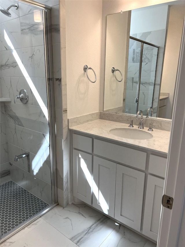 bathroom featuring marble finish floor, a marble finish shower, and vanity