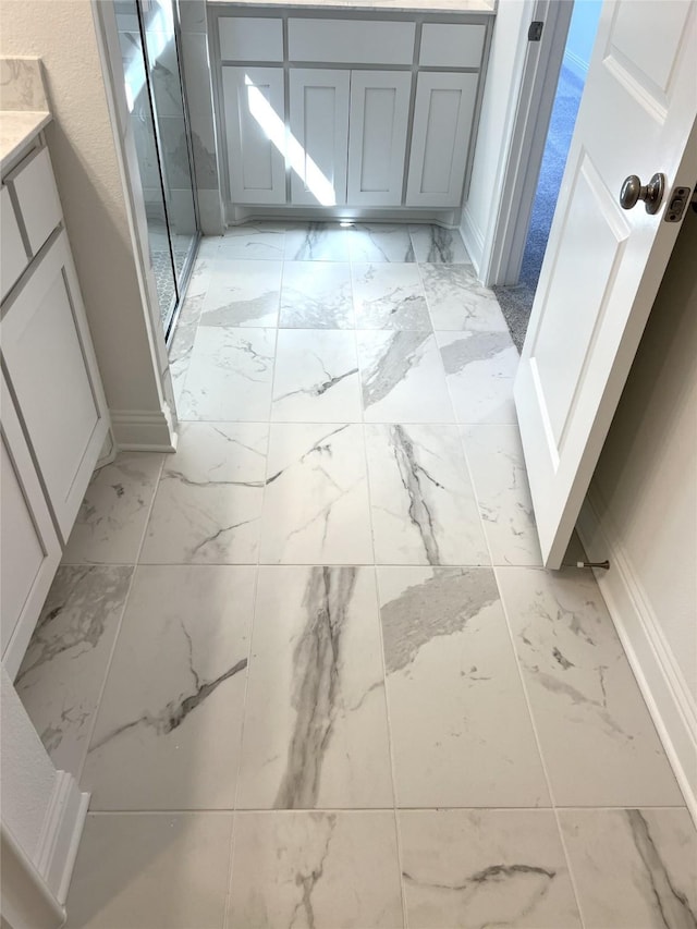 bathroom featuring marble finish floor, baseboards, and vanity