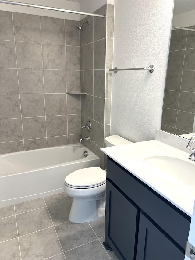 full bathroom featuring a textured wall, toilet, vanity,  shower combination, and tile patterned flooring