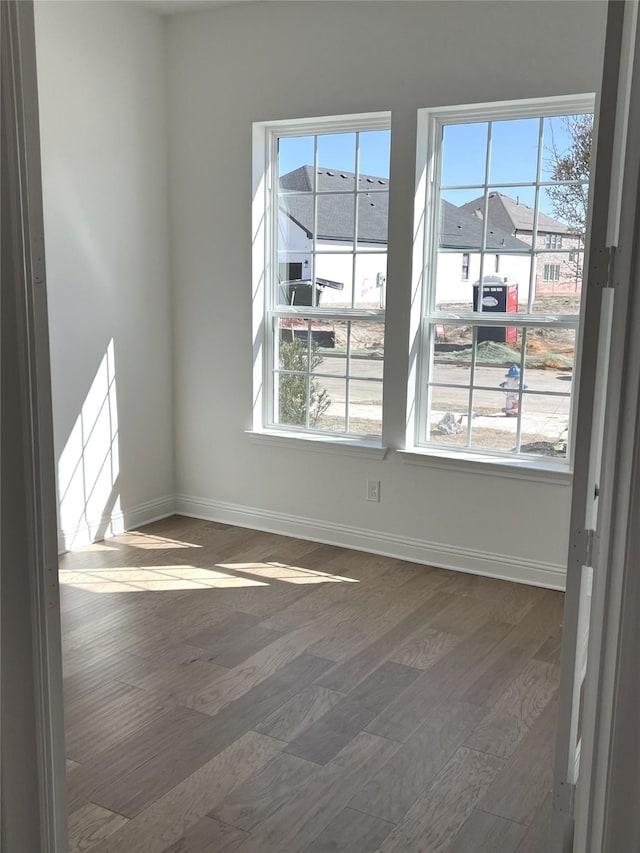 unfurnished room with dark wood-style floors and baseboards