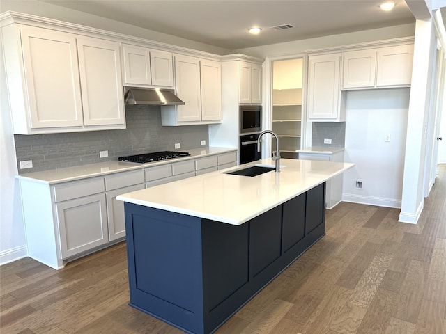 kitchen with stainless steel appliances, dark wood-type flooring, white cabinetry, a sink, and under cabinet range hood