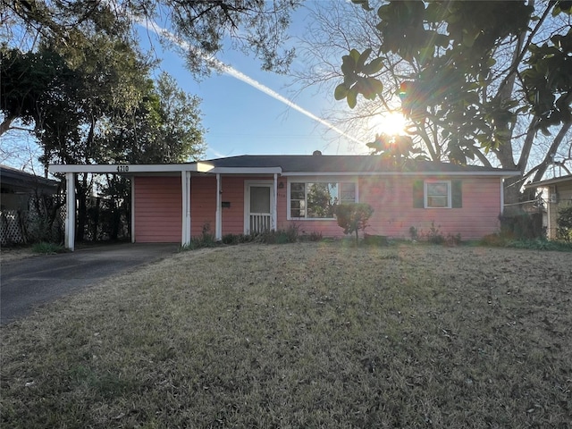 ranch-style home featuring driveway, a front lawn, and an attached carport