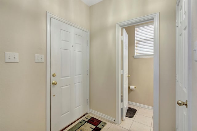 doorway to outside with light tile patterned floors and baseboards