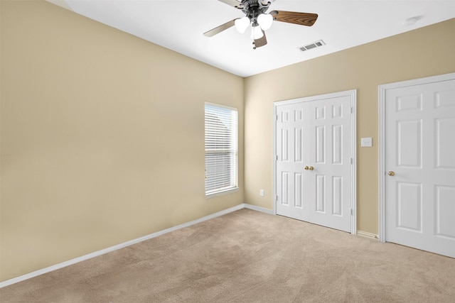 unfurnished bedroom featuring light carpet, baseboards, visible vents, and a closet