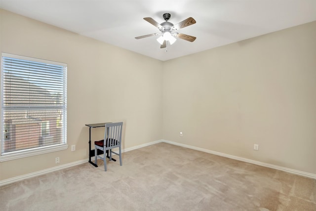 empty room featuring a ceiling fan, light carpet, and baseboards