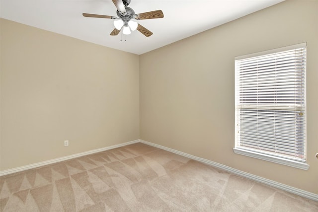 empty room featuring light carpet, ceiling fan, and baseboards