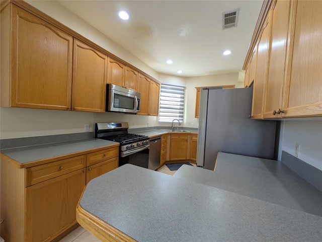 kitchen with stainless steel appliances, recessed lighting, visible vents, a sink, and a peninsula