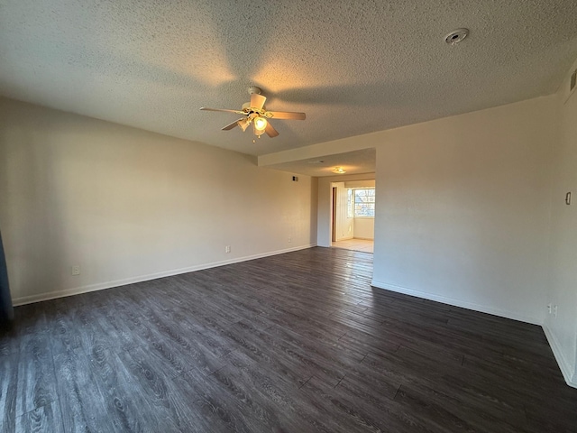 empty room with dark wood-style floors, ceiling fan, a textured ceiling, and baseboards