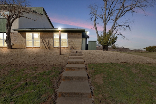 back of house at dusk with brick siding