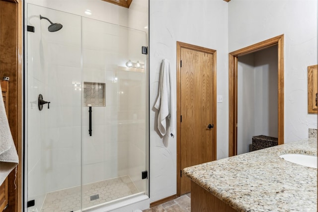 bathroom with a shower stall and vanity