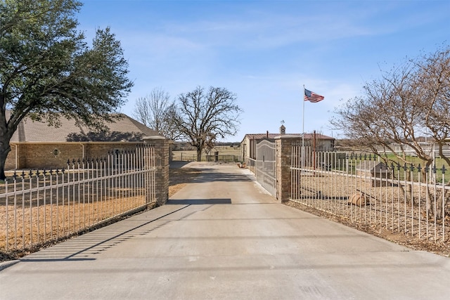 view of road featuring concrete driveway, a gated entry, and a gate